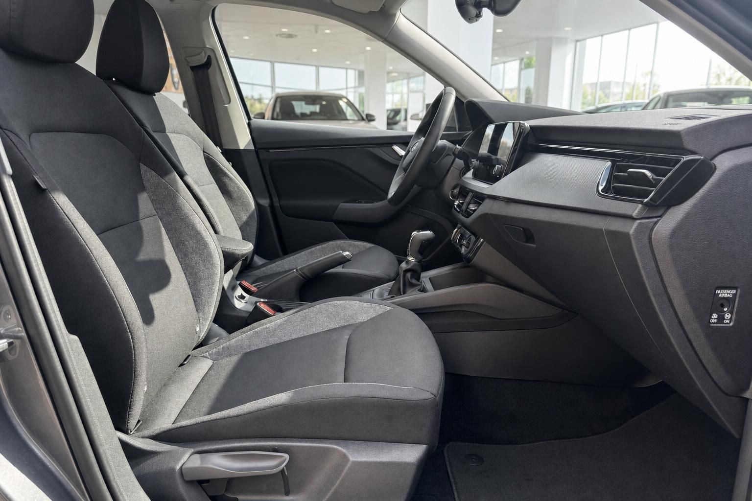 Fahrzeuginnenraum mit schwarzen Stoffsitzen, Mittelkonsole und Armaturenbrett im Autohaus