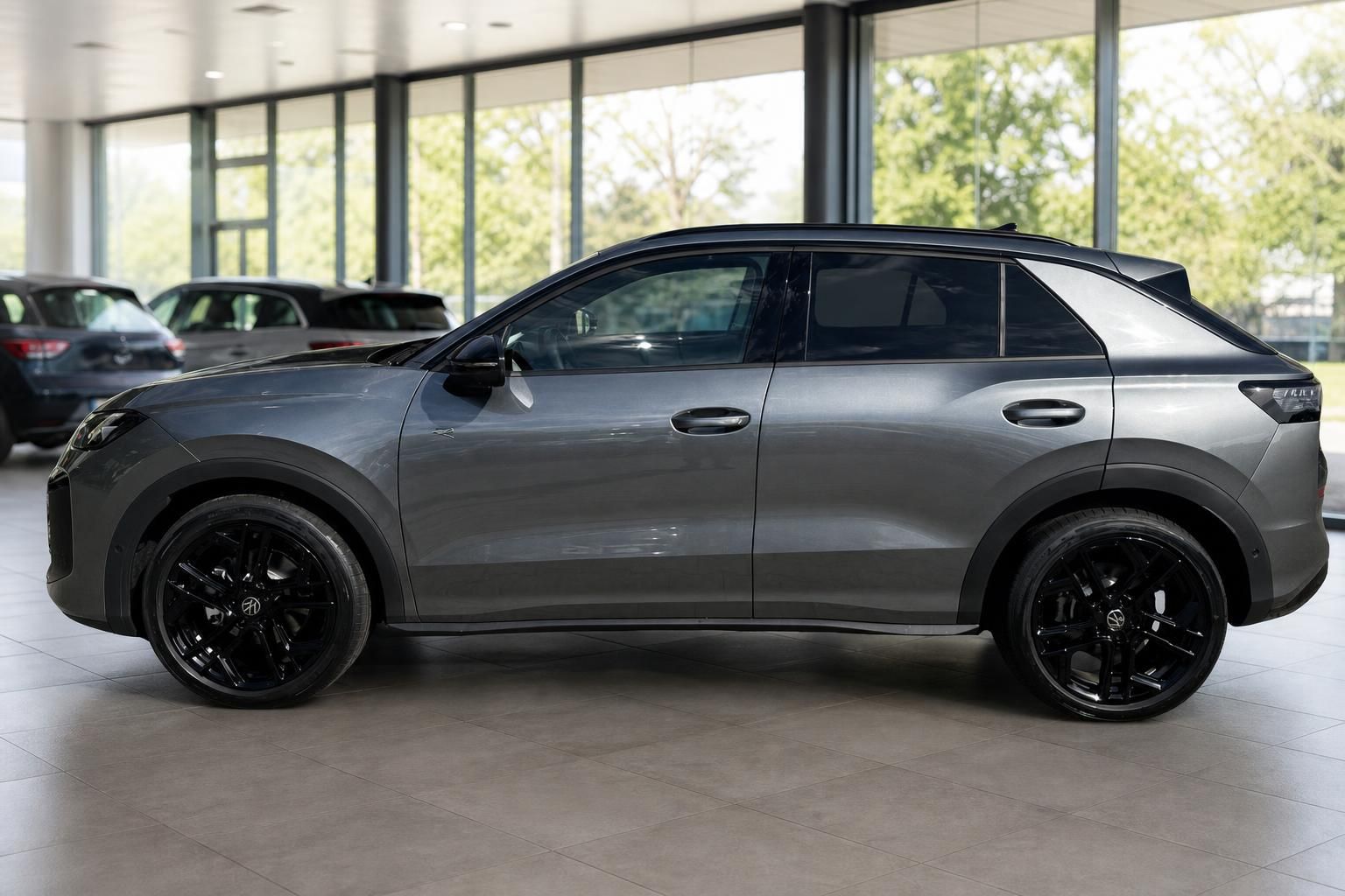 VW Taigo grau metallic Seitenansicht mit schwarzen Felgen im Autohaus